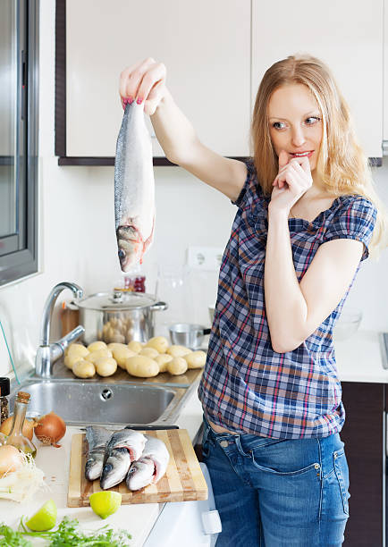 istock Young housewife  thinking how to cook seabass 487177689