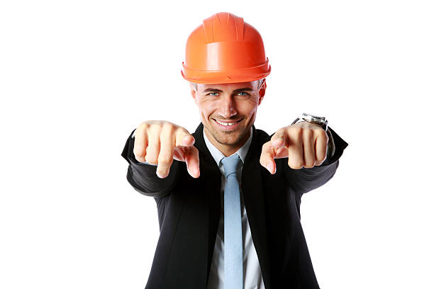 istock businessman in hard hat pointing at you 487178391