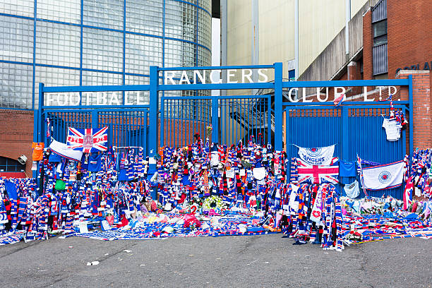 Ibrox Stadium, Glasgow Glasgow, UK - April 26, 2014: Tributes left at the gates of Ibrox Stadium, Glasgow, the home ground of Rangers Football Club, following the death of William "Sandy" Jardine who had played for the club between 1965 and 1982. ibrox stock pictures, royalty-free photos & images
