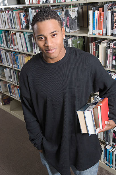 istock Man Holding Books In College Library 487180023