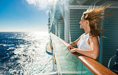 Happy woman looking at sea from a cruise ship.