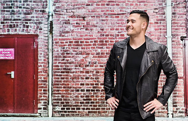 istock Smiling casual man in front of brick wall 487190782