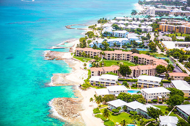 Aerial view of coastline of Grand Cayman, Cayman Islands Stunning aerial view of the coastline of popular vacation location Grand Cayman with it's clear aqua water and beautiful sand beaches. Hotels line the beach which stretches for miles. It is lush and tropical. It's a sunny perfect day in the Caribbean. cayman islands stock pictures, royalty-free photos & images