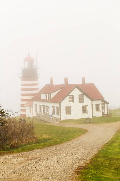 West Quoddy Head Light in Heavy Fog Popular tourist sight West Quoddy Head Light shrouded in fog so thick that the Atlantic Ocean below is not visible.  Vertical format. quoddy head state park stock pictures, royalty-free photos & images