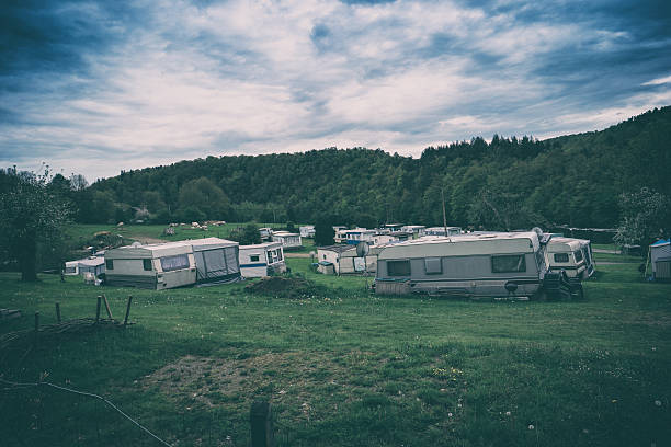 Desolate camping site showing old caravans under looming sky stock photo