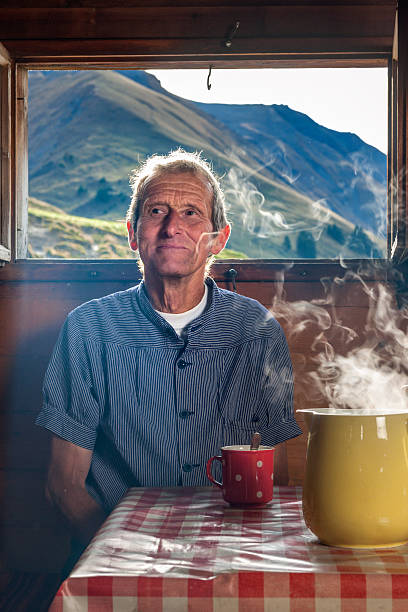 farmer trinkt kaffee im farmhouse, schweiz - shack european alps switzerland cabin stock-fotos und bilder