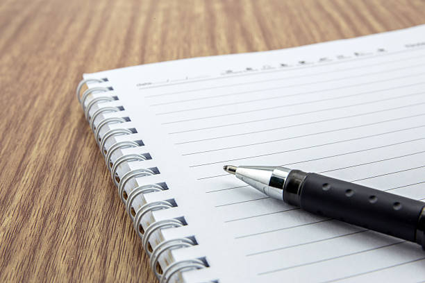 istock notepad with pen lying on the wooden table 487205928