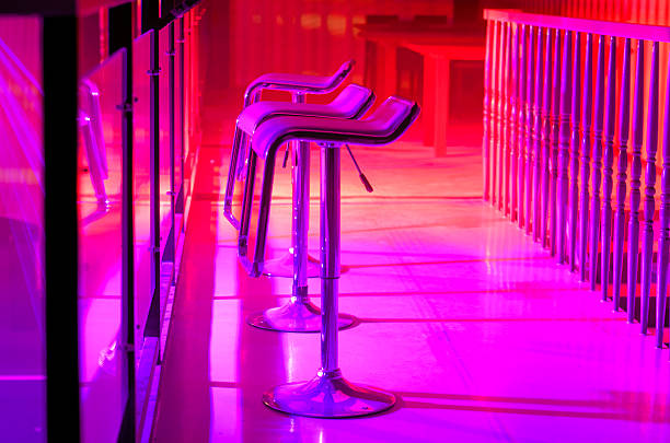 istock Row of Empty Bar Stools Along Bar in Night Club 487206538