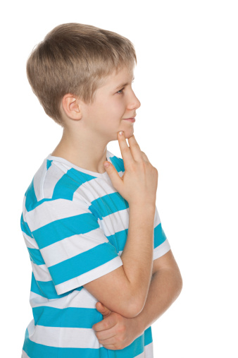 A profile portrait of a preteen boy on the white background