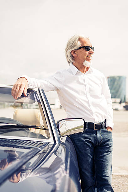 istock senior man standing next to convertible classic car 487209798