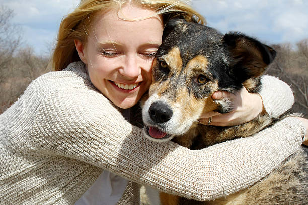 primo piano di donna abbracciare pastore tedesco cane - christin foto e immagini stock