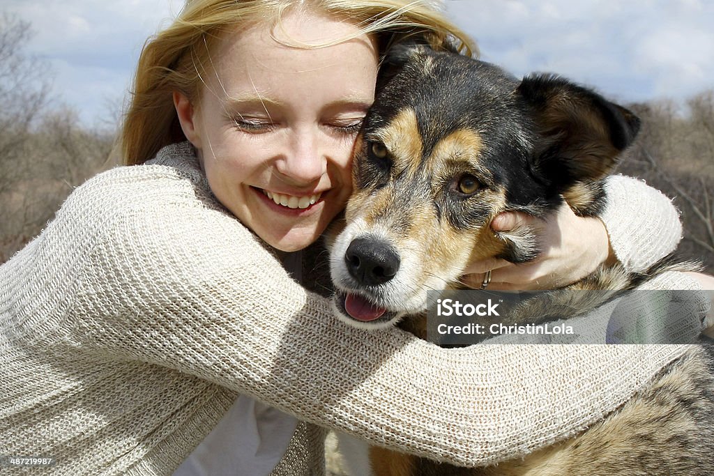 Close up of Woman Hugging German Shepherd Dog a loving and candid portrait of a happy woman hugging her large German Shepherd dog. Dog Stock Photo