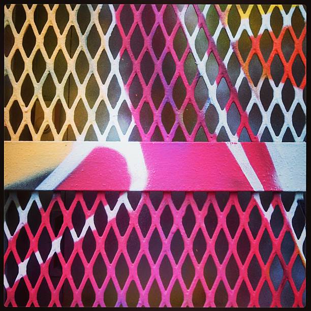 This is a square, mobilestock, close up color photograph of a spray painted metal door in Wynwood, Miami.