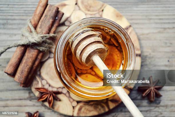 Golden Honey With Honeystick Cinnamon And Anise Stars Stock Photo - Download Image Now