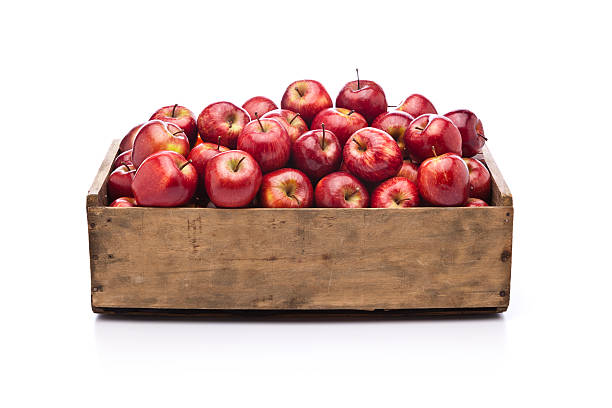 pommes rouges dans une boîte en bois isolé sur fond blanc - caisse en bois photos et images de collection