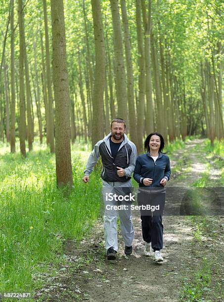 Middleaged Couple Jogging Stock Photo - Download Image Now - 40-44 Years, Active Lifestyle, Active Seniors