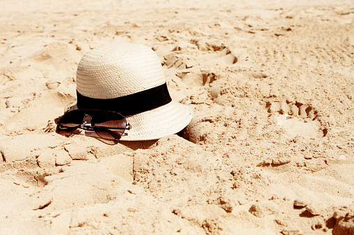 hat and sunglass on a beach