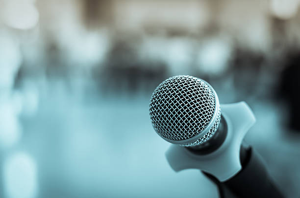 istock Close up of microphone in conference room on blurred background 487230828