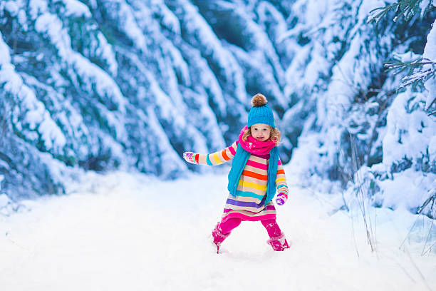 istock Little girl playing in snowy winter forest 487233764