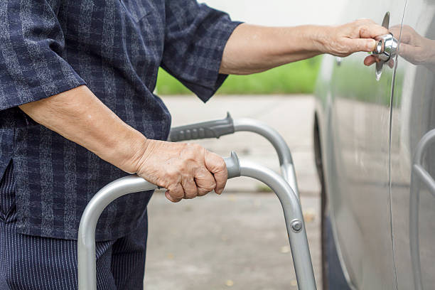 istock senior woman using a walker at car park 487234984