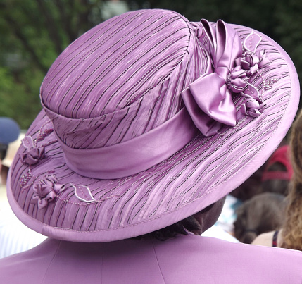 Hanover, NH, USA – June 10, 2012: Woman wearing decorative purple hat and matching suit seated in the audience \