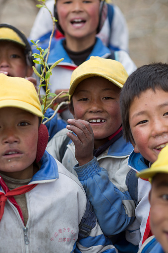 Lhasa, China - April 17, 2013: Unidentified group of Kids playing with a red Chinese flag in the countryside of Lhasa. China