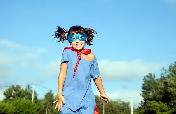Little girl having fun with her handmade disguise of superhero.