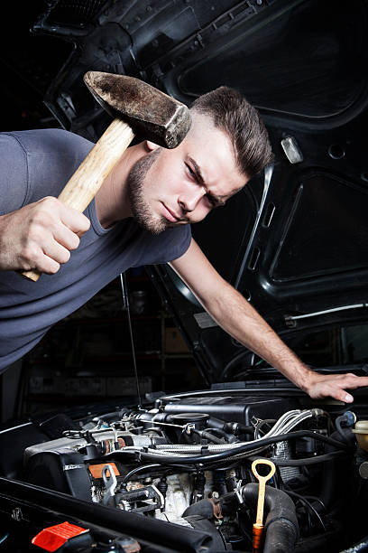 istock Funny mechanic car repair engine motor hammer 487242896