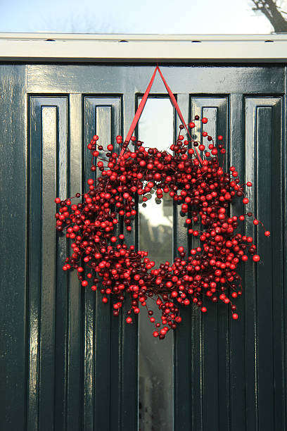 istock Berry christmas wreath with decorations on a door 487243658