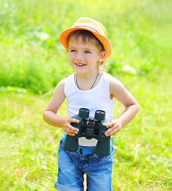 istock Happy child boy with binoculars outdoors in summer day 487250272