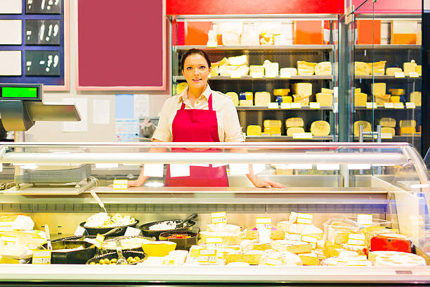 sales clerk at the dairy counter - cheese counter supermarket bildbanksfoton och bilder