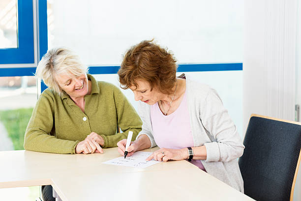 istock illiterate women learn writing with teacher in classroom 487253703