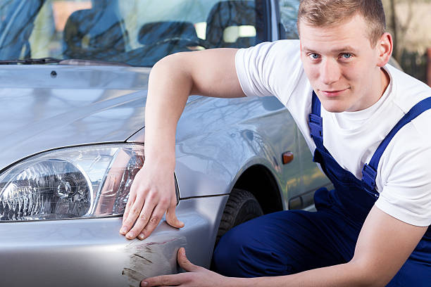 Mechanic repairing car scratching Handsome mechanic during repairing car scratching, horizontal bumper photos stock pictures, royalty-free photos & images