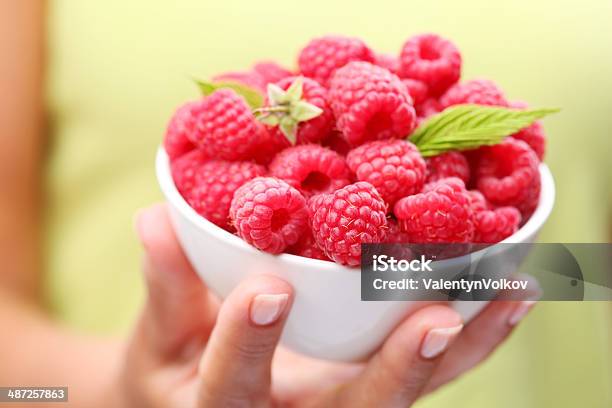 Crockery With Raspberries In Woman Hand Stock Photo - Download Image Now - Adult, Backgrounds, Bowl