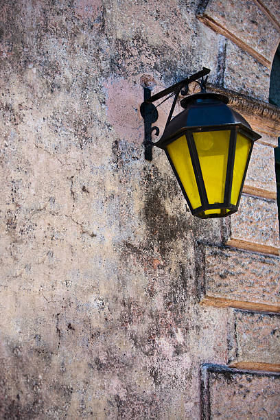 istock Colonial Yellow Street Lamp Hanged on Wall 487259410
