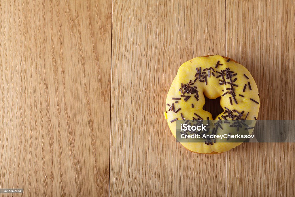 Yellow donut Yellow donut on wood table 2015 Stock Photo
