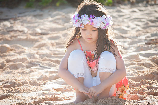 niedliche kleine hawaiian mädchen am strand mit nachdenklichen ausdruck - child praying beach little girls stock-fotos und bilder