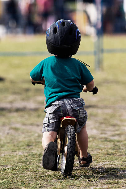 Top view of pretty young girl with long light brown hair riding a bicycle on cool spring day looking upward. Outdoors activities.healthy lifestyle and happy childhood.