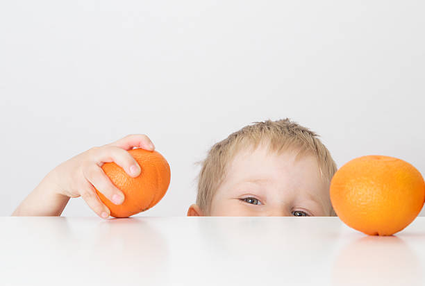 istock little boy with oranges, healthy food 487273345