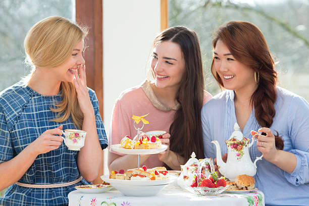 tre amici avendo tè pomeridiano - tea women tea party afternoon tea foto e immagini stock