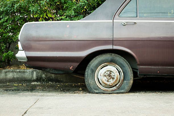 abandoned car with a flatted tyre stock photo