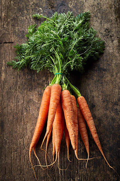 istock fresh carrot bunch on old wooden table 487277051