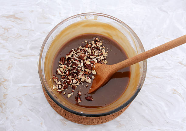 istock Stirring chopped pecan nuts into filling for pecan pie 487277442