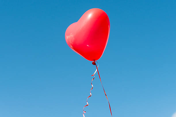 istock Valentine heart balloon against blue sky background 487288112