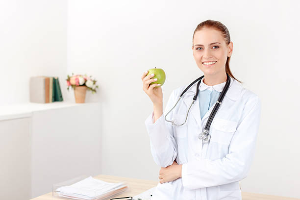 istock Positive doctor holding green apple 487288536