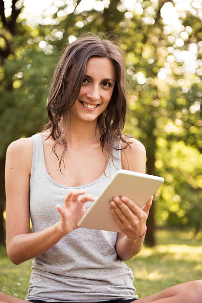 istock Young woman with digital tablet at the park 487288950