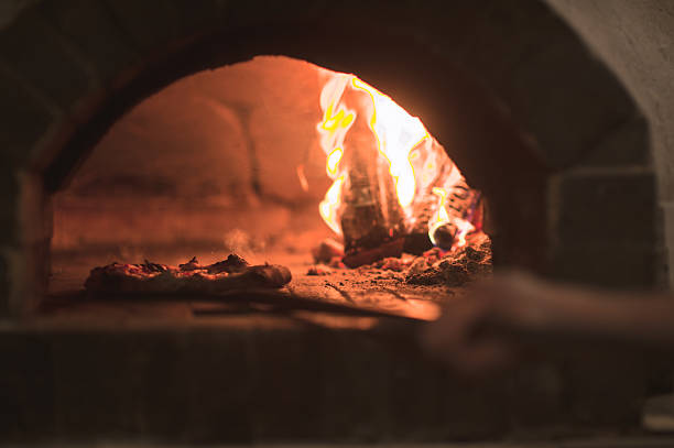 istock Pizza baking in an open firewood oven 487291244