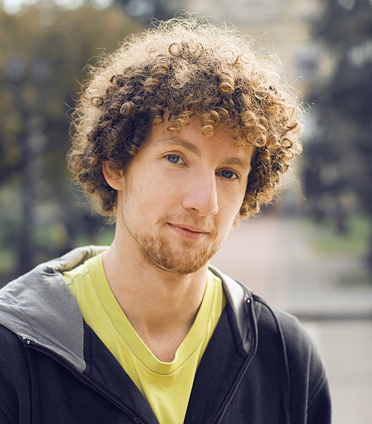 istock Young Curly man Portrait Outdoors in Park 487295251