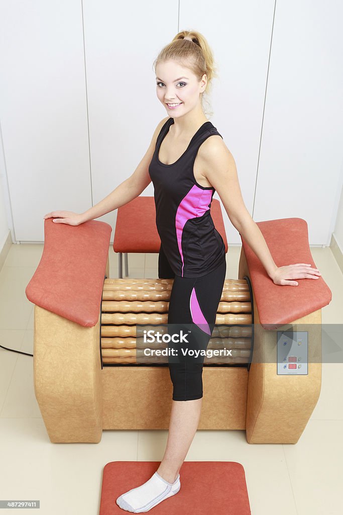 Chica en sportwear utilizando equipos saludables, relájese con un masaje en el spa salon - Foto de stock de Acogedor libre de derechos