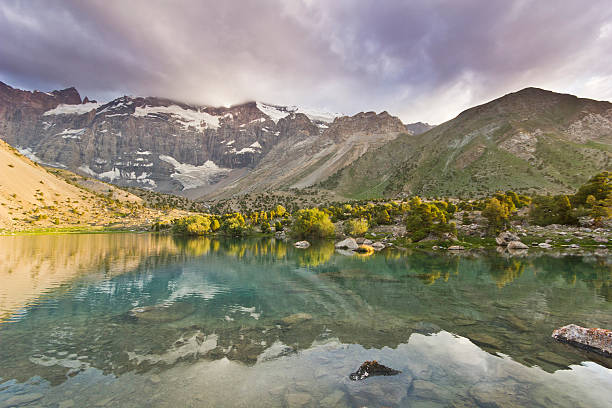 istock blue mountain lake surrounded by high peaks at sunset 487297446